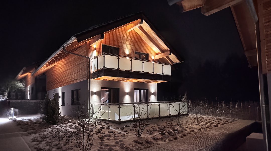 Chalets revestidos de madera en Hahnenklee por la noche, con las ventanas iluminadas y la nieve