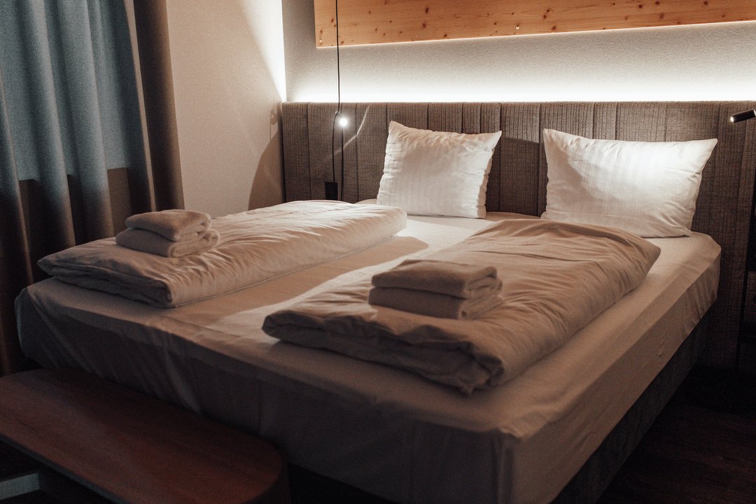 Schlafzimmer eines Chalets am Abend mit indirekter Beleuchtung