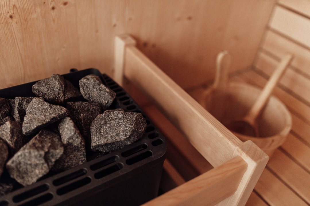 Saunaovn med sten og træbænk i saunaen i et chalet