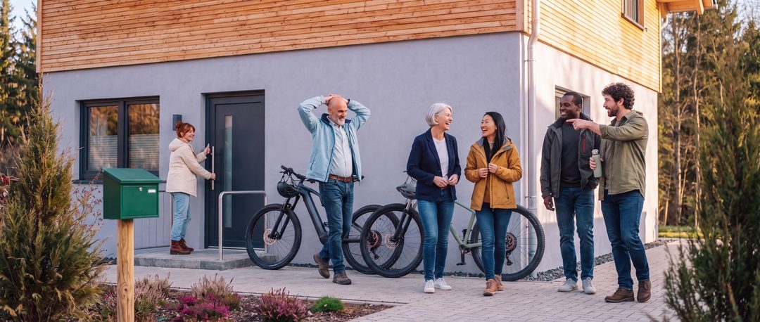 After finishing work, the team steps out of the front door of a chalet in high spirits; one colleague stretches, two female colleagues laugh – illustrative image